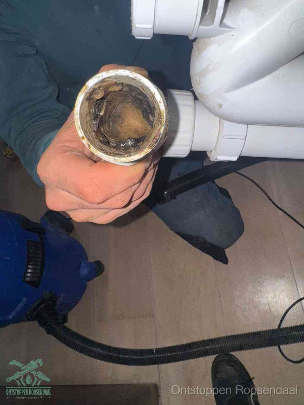 Een losgekoppeld afvoerbuisstuk dat van binnen volledig is dichtgeslibd, het gevolg van een verstopping te lang laten zitten in Roosendaal