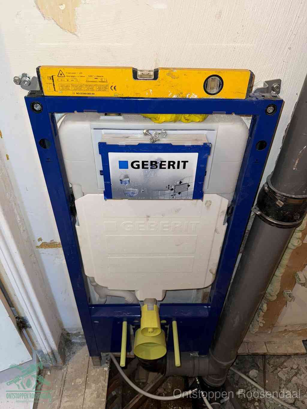 Een Geberit inbouwreservoir met frame voor een hangtoilet tegen de wand, met de afvoerbocht naar de vloer, kenmerkend voor een verstopt hangtoilet in Roosendaal