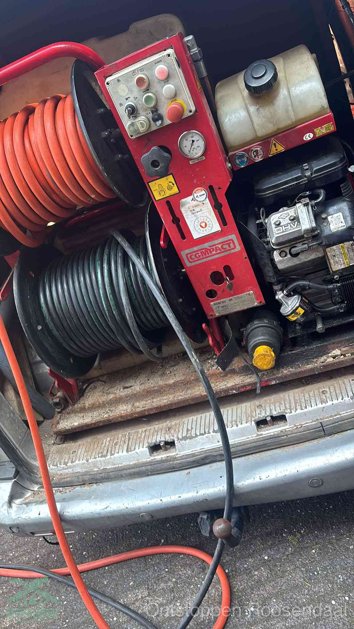 Een rood hogedruk-rioolreinigingstoestel in de laadbak van de bedrijfsbus, apparatuur voor een hardnekkige afvoerverstopping in Roosendaal