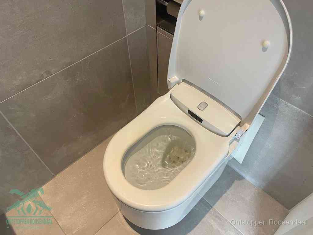 Een toiletpot vol troebel water met drijvend papier en restanten, de meest voorkomende oorzaak van een verstopte wc in Roosendaal