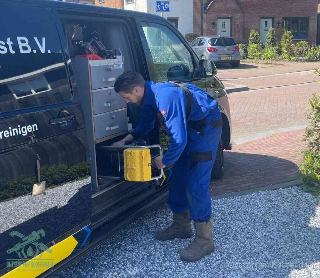 Een monteur pakt apparatuur uit de bedrijfsbus voor service aan huis, het moment om een professional in te schakelen in Roosendaal
