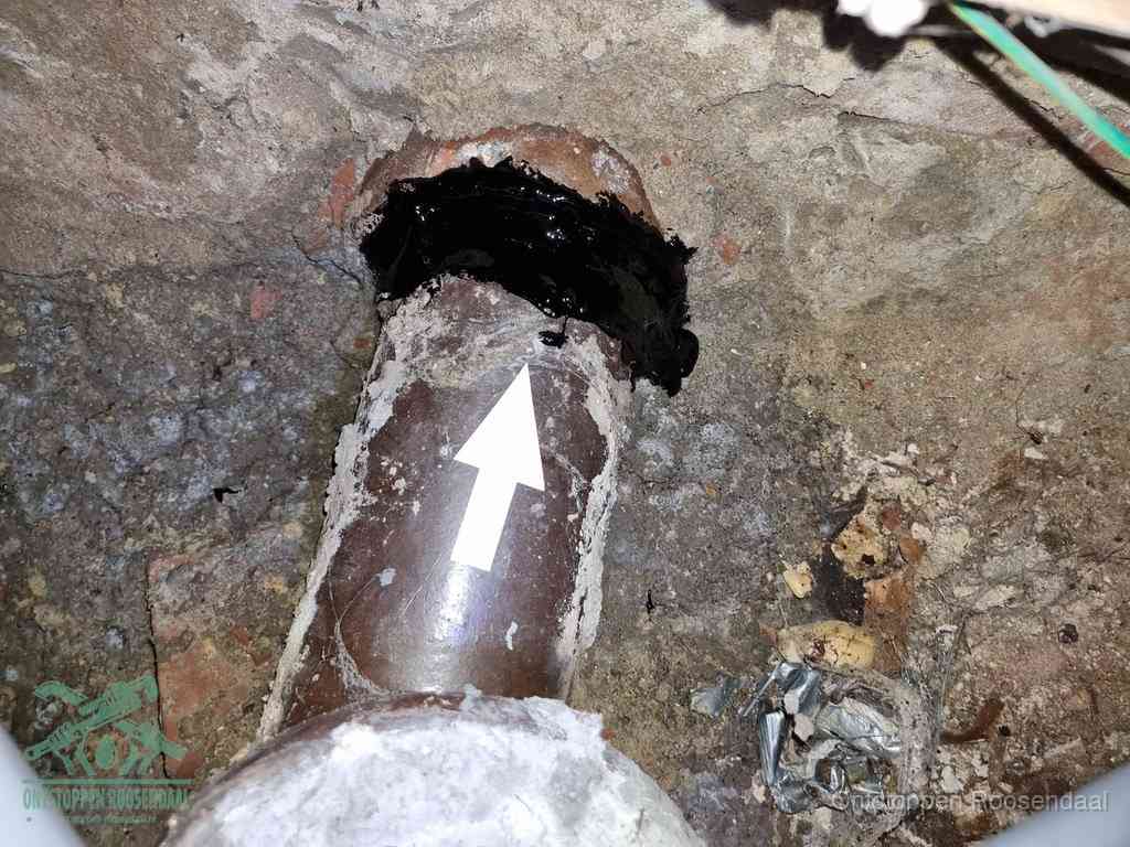 Een oude gres rioolbuis met een beschadigde koppeling onder de vloer, oorzaak van terugkerende structurele wc-problemen in Roosendaal